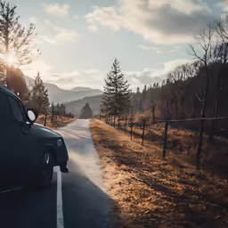 a truck drives down the road next to a mountain