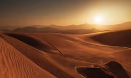the sun is setting over the hills in the desert