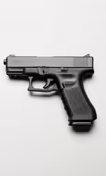a gun sits atop the surface of a white background