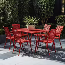 a table with chairs and potted plant sitting outside