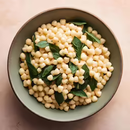 there is a bowl of corn and basil on the table