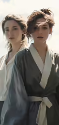 two women in matching outfits stand next to each other
