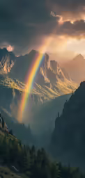 a rainbow is seen over the valley and mountain ranges