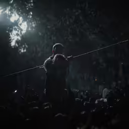 a person in the dark holding a small pole above them