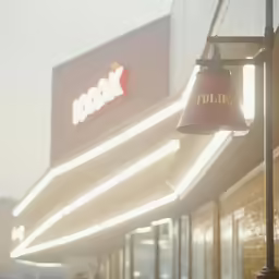 a large restaurant sign and lamp in front of it