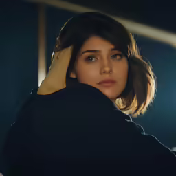 a woman with shoulder length black jacket and black sweater