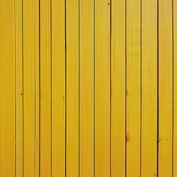 the back of a yellow wooden fence and green grass
