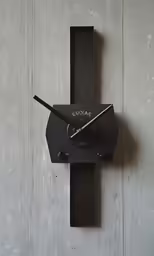the clock is connected to a long, rectangular piece of wood