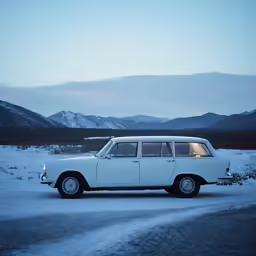 an old, well maintained, wagon is parked on a road in the snow