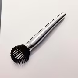 a hair brush on a white surface with clippings