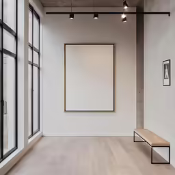 an empty room with wooden floors and a bench