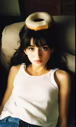 young woman wearing white tank top with donut on her head