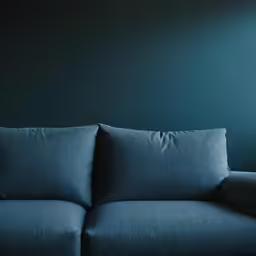 an unfurnished couch on an end table against a green wall