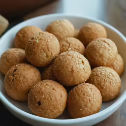 a white bowl filled with cooked meatballs sitting on a table