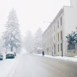 street scene of a snow covered street and cars