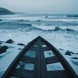 a long boat on the beach next to a shore
