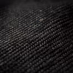 black and white photograph of an area rug,an up - close view of an up - close object that looks like it has a black cloth with tiny stitches