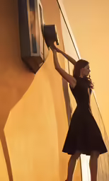 a woman standing next to a building with her hands on the handle of a hair dryer