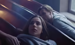 two people on a bench while wearing blankets