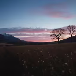the sun is setting over the mountain side