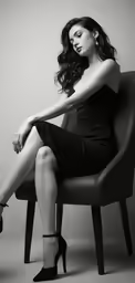 a young woman sitting in a chair with heels