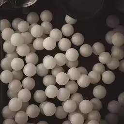 a bunch of white balls sitting inside of a container
