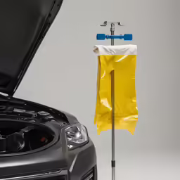 a yellow plastic bag sticking out from under the hood of a car