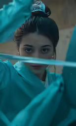 the woman in the blue robes is looking out from a corner