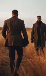 two men in a field with wheat stalks