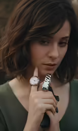 a girl with a watch holds her finger to her hand