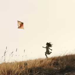 the girl is flying a kite on the hill