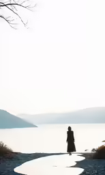 a woman walks across a river on a windy day