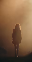 a woman walking away in a mysterious looking light