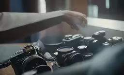 a person holding something with one hand over many cameras