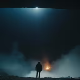 a person standing in front of the sky and stars