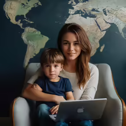 a woman and child using an apple laptop
