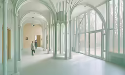 there is a man walking through the hall of an older building
