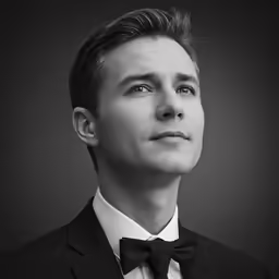 a black and white image of a man in a tuxedo