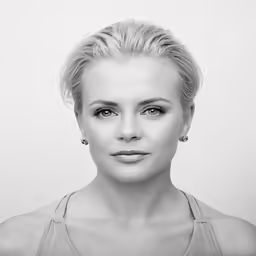 a woman wearing a tank top and earrings