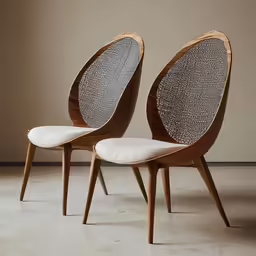 two white fabric - covered chairs with wooden back legs