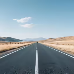 there is a person walking on the empty road