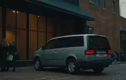 a person standing next to a car and holding a bag