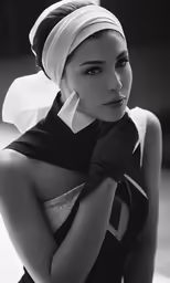 a woman with her arms crossed wearing a turban