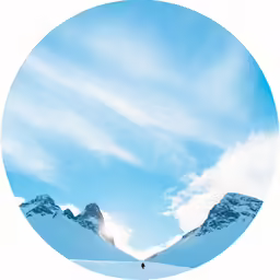 a man is standing on the snow with mountains in the background