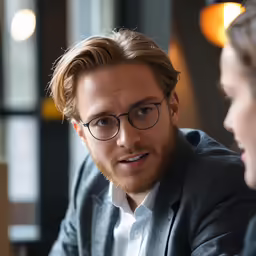 the two men are sitting together talking to each other