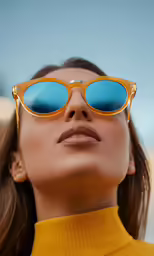 woman in glasses with a collared shirt and gold frame