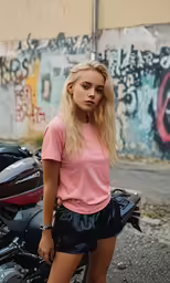 a woman leaning against a motorcycle with graffiti on the back