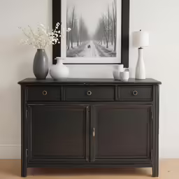 a picture of a black buffet buffet with white flowers and pictures above it