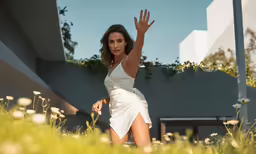 a woman is reaching into the air in her white dress
