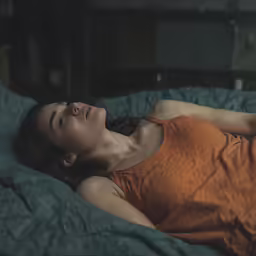 a woman laying in bed with a blanket